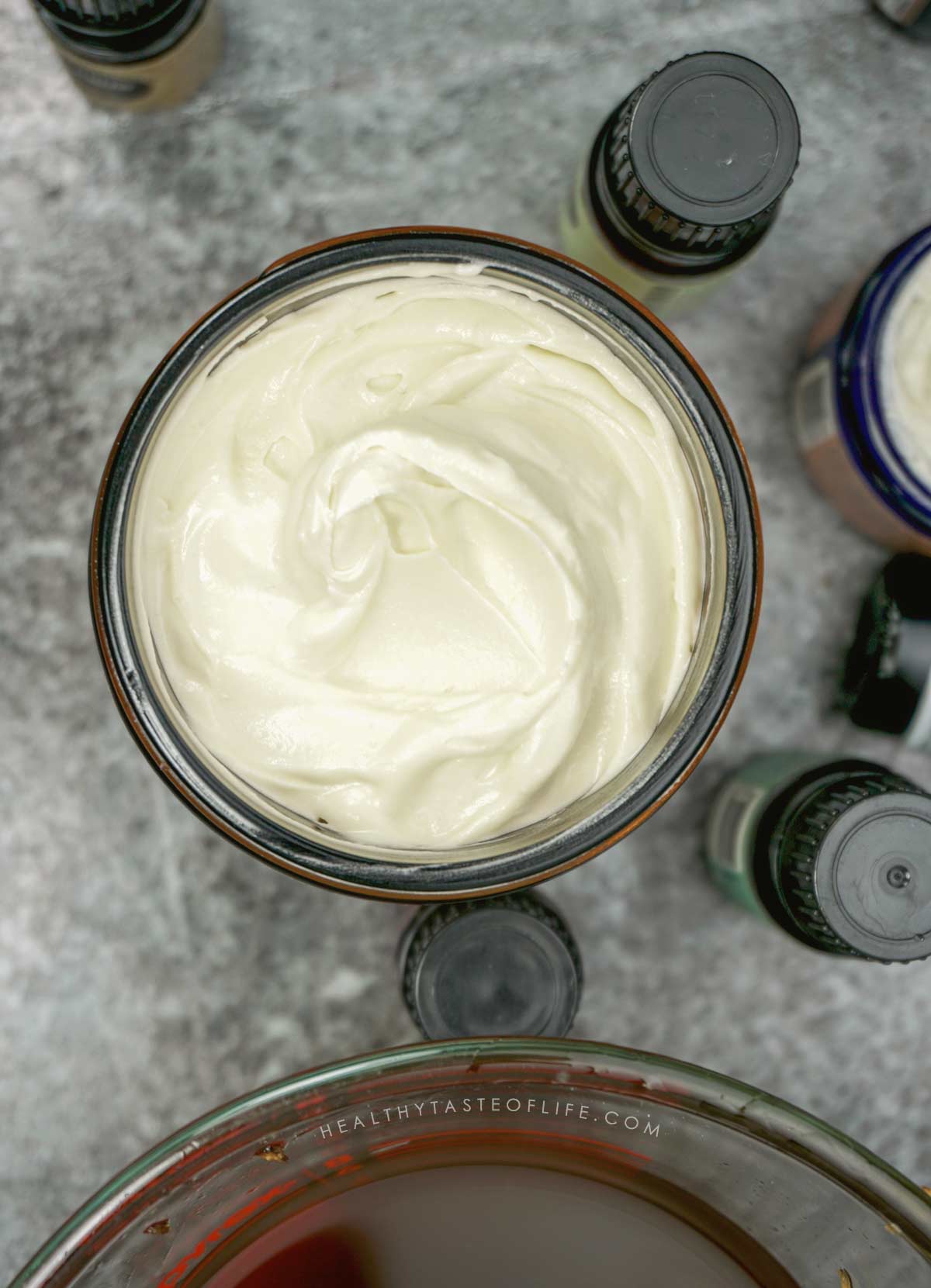Homemade soft creamy whipped mango body butter transferred to a glass jar.