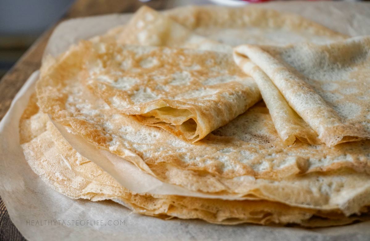 Stack of thin gluten free crepes before kept covered to stay soft and flexible