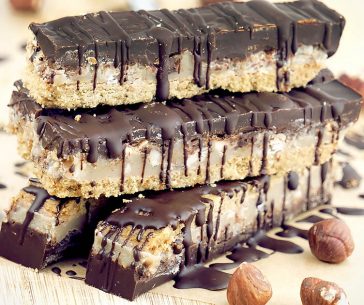 Homemade Chocolate Caramel Hazelnut Bars with a gluten free shortbread crust, dairy free chewy caramel, crunchy hazelnuts and a rich coating of high quality chocolate. These homemade candy bars are also vegan, soy free and refined sugar free.