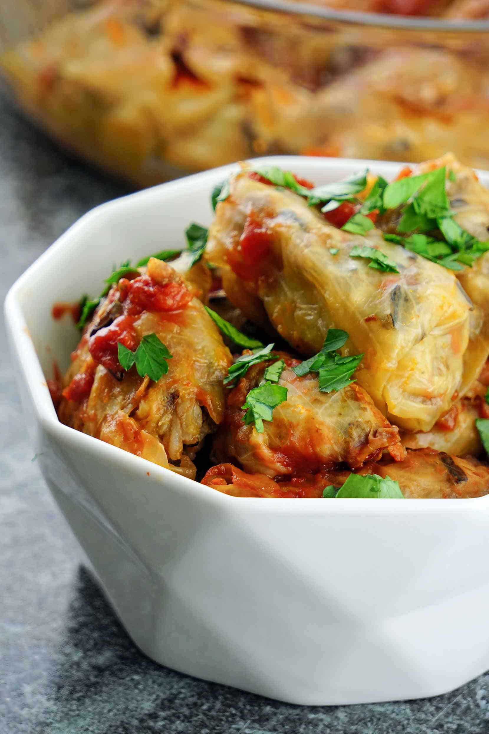 These healthy stuffed cabbage rolls make a delicious gluten free, dairy free, clean eating dinner or lunch. The cabbage leaves are stuffed with a mix of wild rice and basmati rice, seasoned grass fed ground beef, caramelized veggies and baked in the oven until moist and tender.