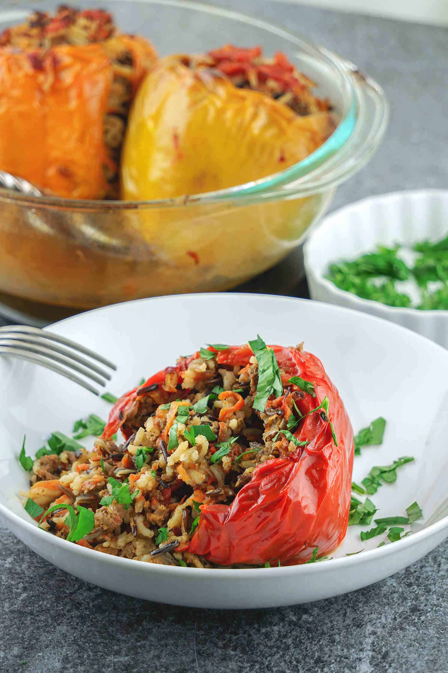 Healthy stuffed peppers – a comforting gluten free, dairy free, clean eating recipe great for dinner or lunch. The bell peppers are stuffed with a mix of wild rice and long grain rice, organic grass fed ground beef, caramelized veggies, aromatic herbs, spices and baked in the oven until moist and tender.