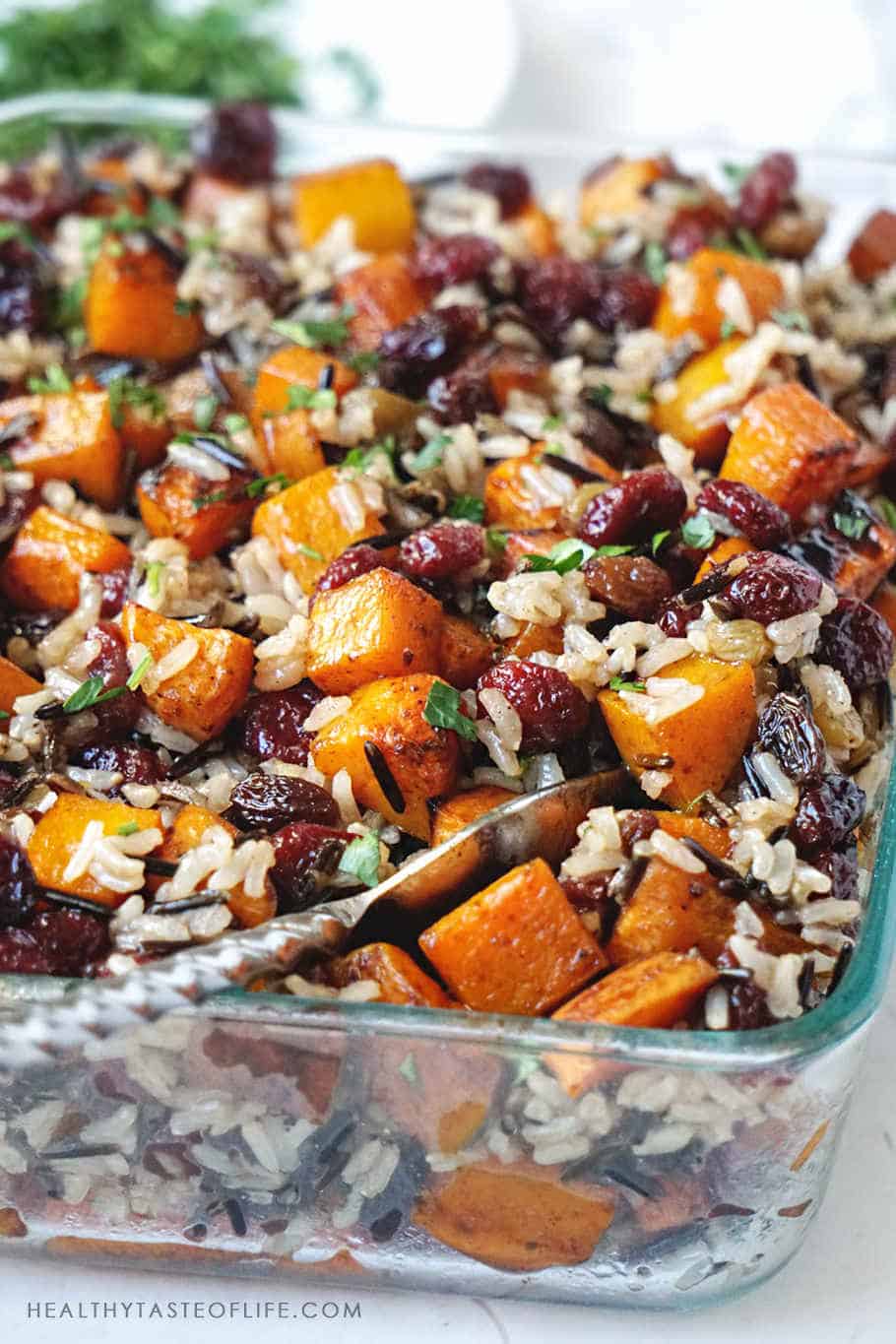 Butternut squash casserole recipe (healthy, vegan side dish) with roasted sweet potatoes, butternut squash, cranberries, complemented by earthiness of brown rice and wild rice and finished with  sweet balsamic notes. It's great as a side dish or as meal during fall or holiday season (Thanksgiving or Christmas) #butternutsquash #butternutsquashcasserole #sweetpotatocasserole #thanksgiving #thanksgivingsidedish   