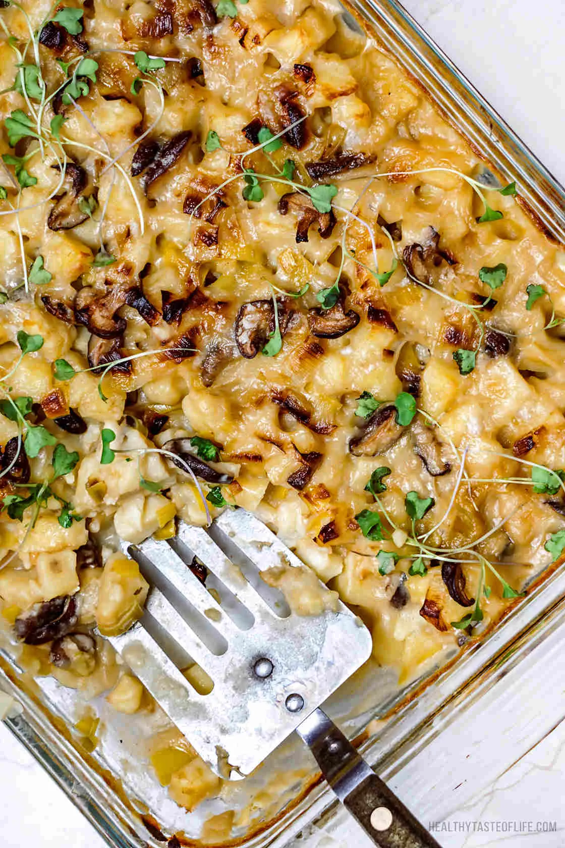 Vegan potato bake or vegan potato casserole made with russet potatoes, mushrooms, a creamy dairy free sauce and vegan feta cheese baked in the oven until golden.