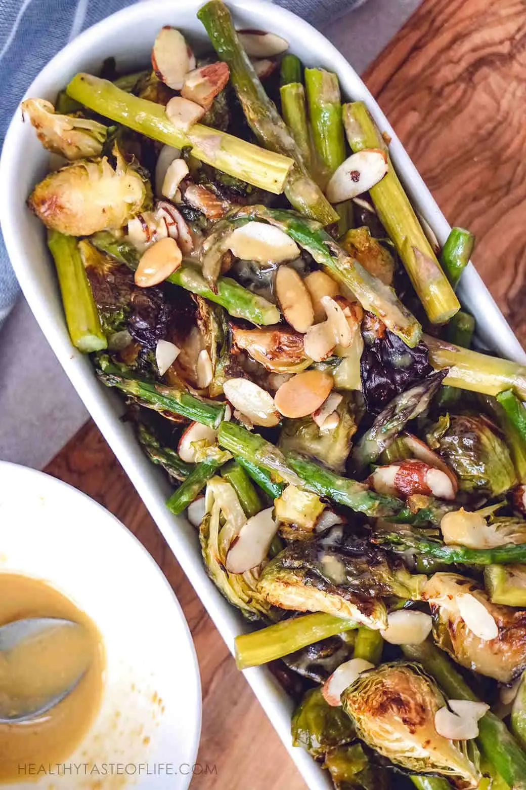 Crispy oven roasted Brussels sprouts asparagus and toasted almonds baked to perfect golden brown and served with a maple lemon Dijon mustard sauce for an extra kick
