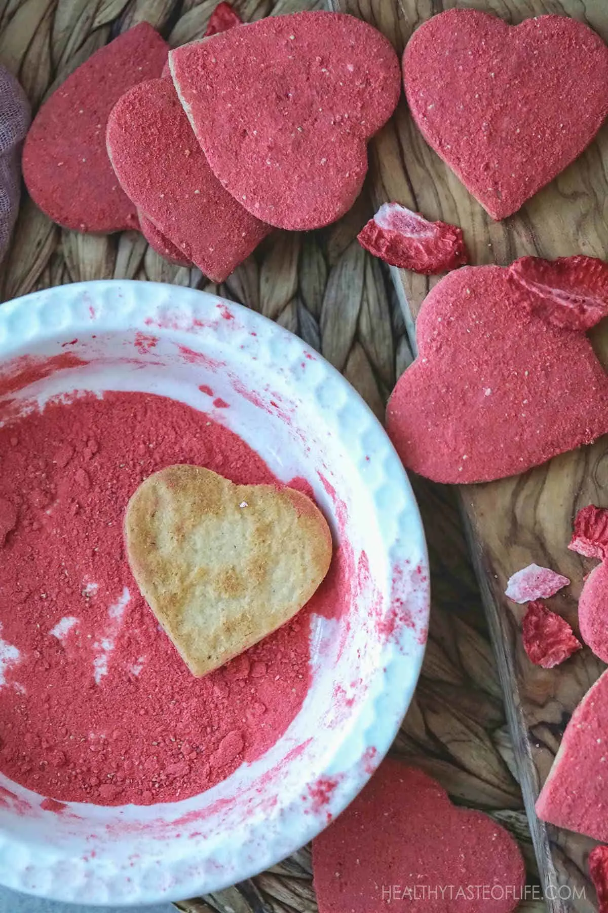 Dredging the vegan cookies in strawberry powder.