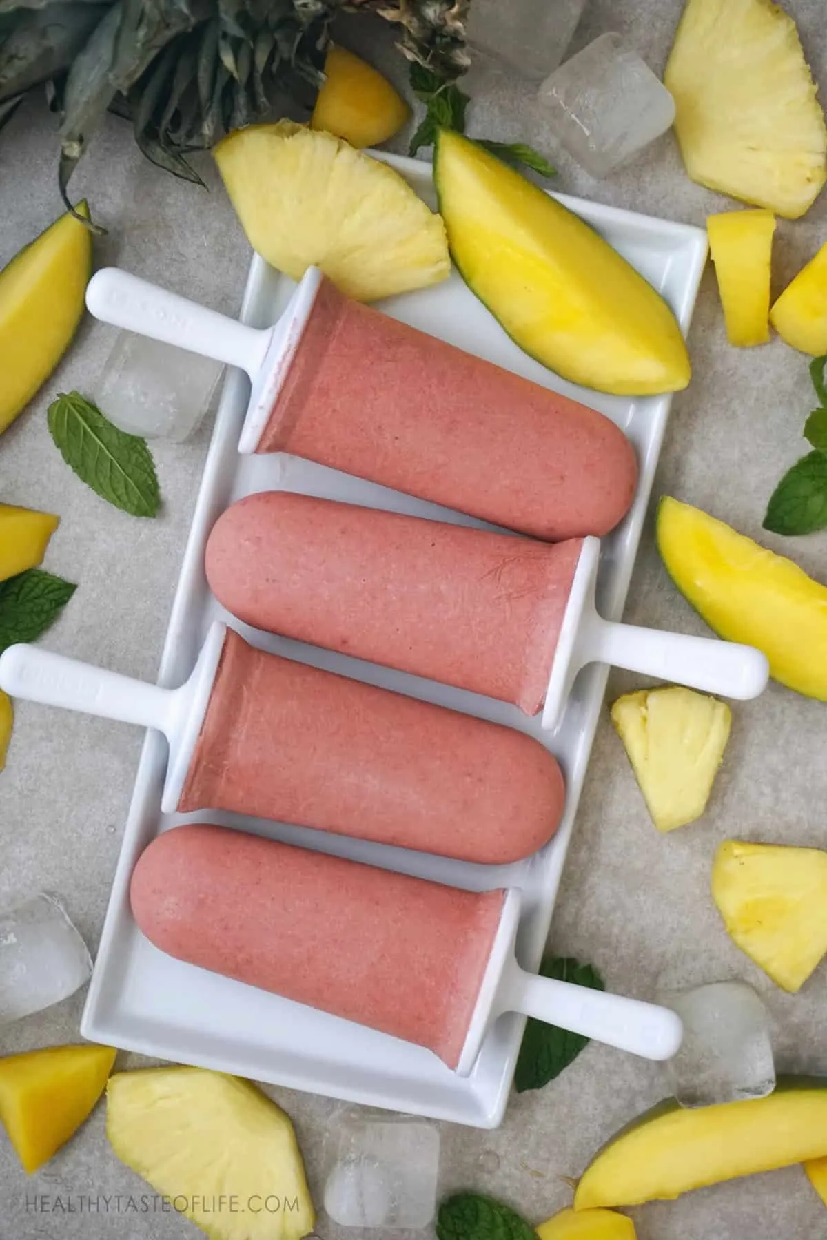 Healthy, easy tropical fruit popsicles - made with all real fruit and no added sugar. A delicious homemade popsicle recipe for kids or adults. These tropical popsicles are vegan, paleo and whole30 friendly. #popsicles #sugarfreepopsicles #popsiclerecipes