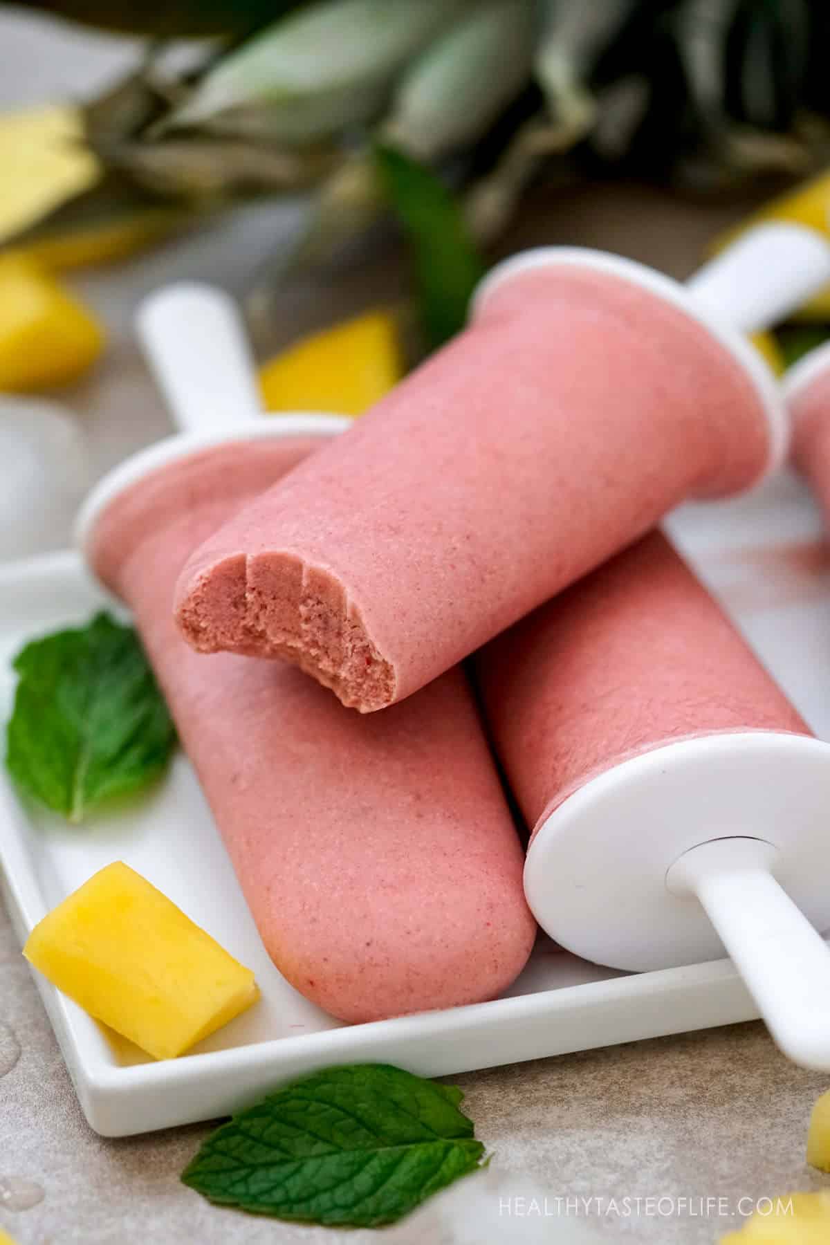 Healthy tropical popsicles - made with only whole fruits like mango, pineapple, banana and strawberry, no sugar added, no juice and no dairy. These tropical fruits popsicles are not overly sweet, but creamy - perfect for kids or adults during hot summer days. #popsicles #popsiclesrecipe #sugarfreepopsicles #tropicalpopsicles #dairyfreepopsicles #tropicalicepops #popsiclesideas