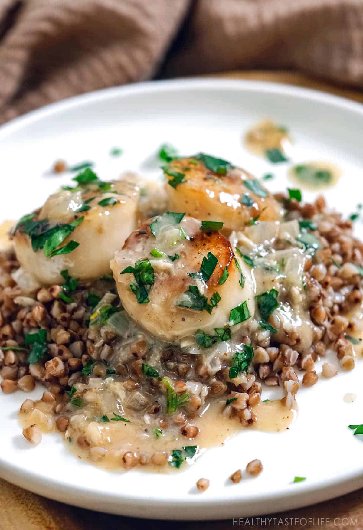 Gluten free scallops dinner: pan seared scallops with dairy free white sauce served over buckwheat. 