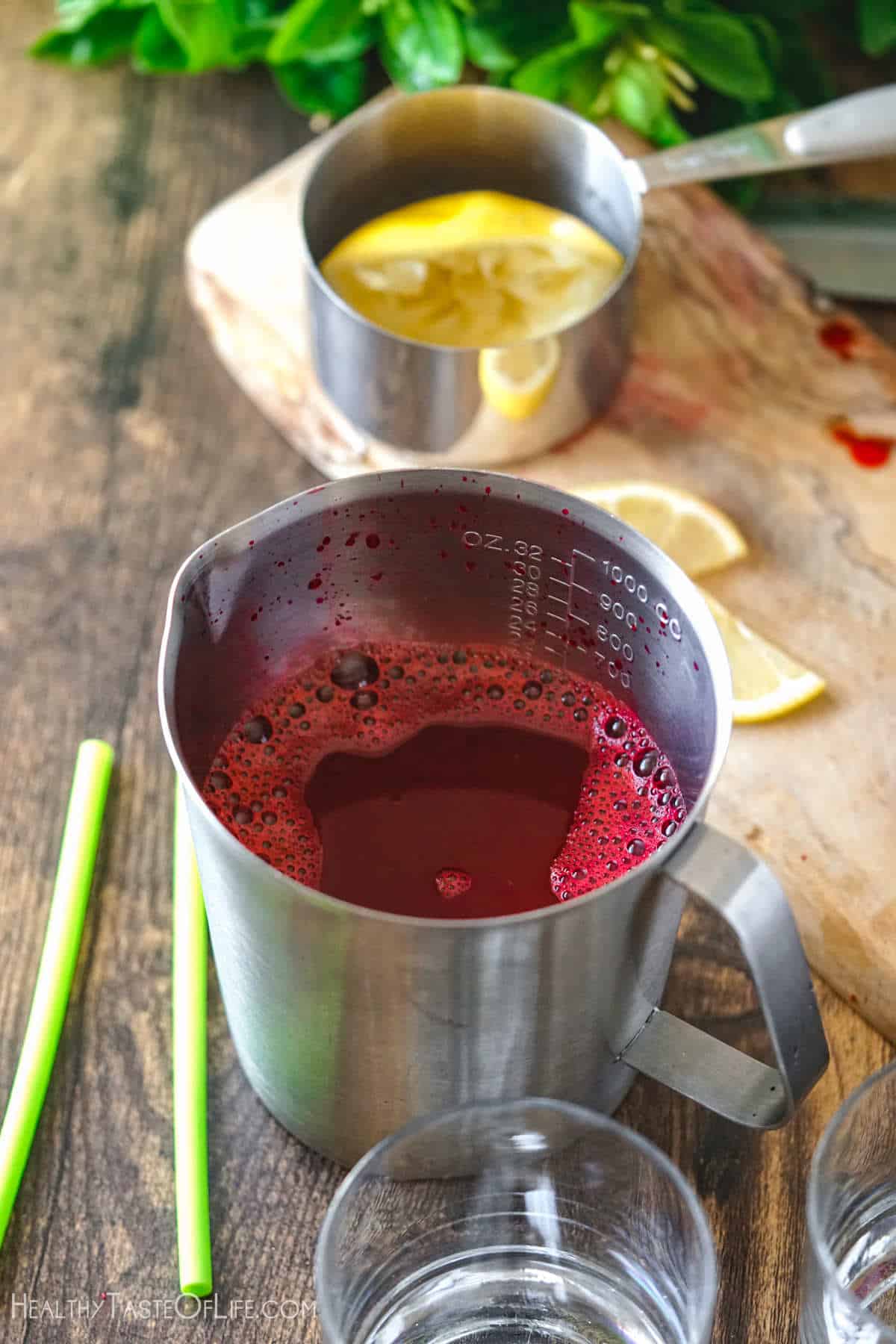 Freshly squeezed beet juice with apple and carrots in a container.
