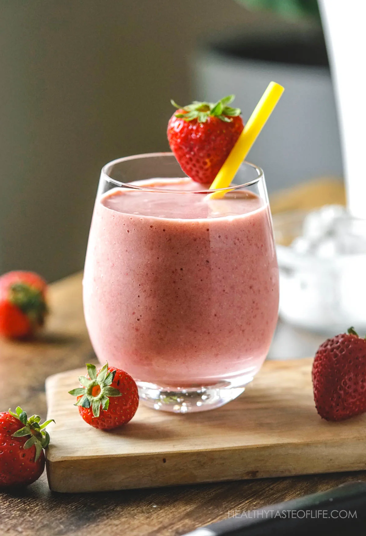 Strawberry banana milkshake in glass garnished with a strawberry.