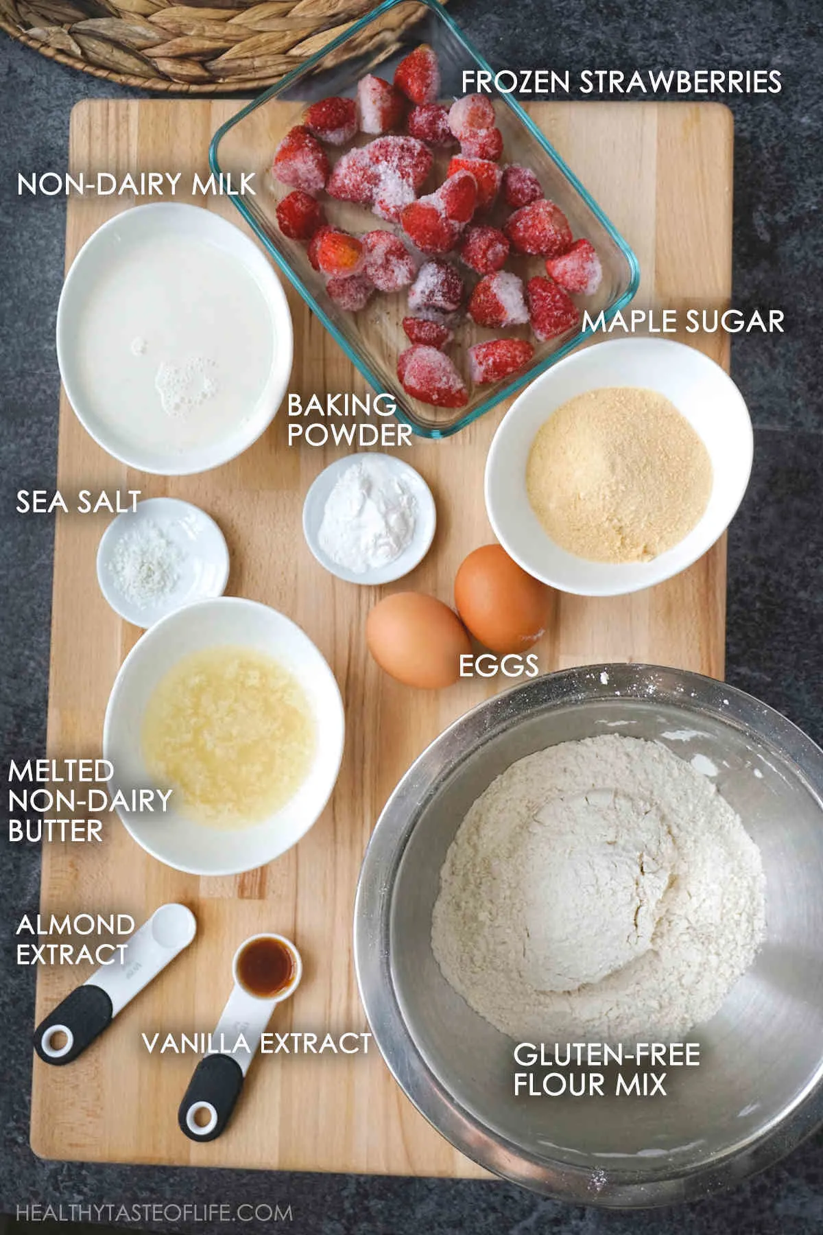 Ingredients for strawberry muffins displayed on a board.
