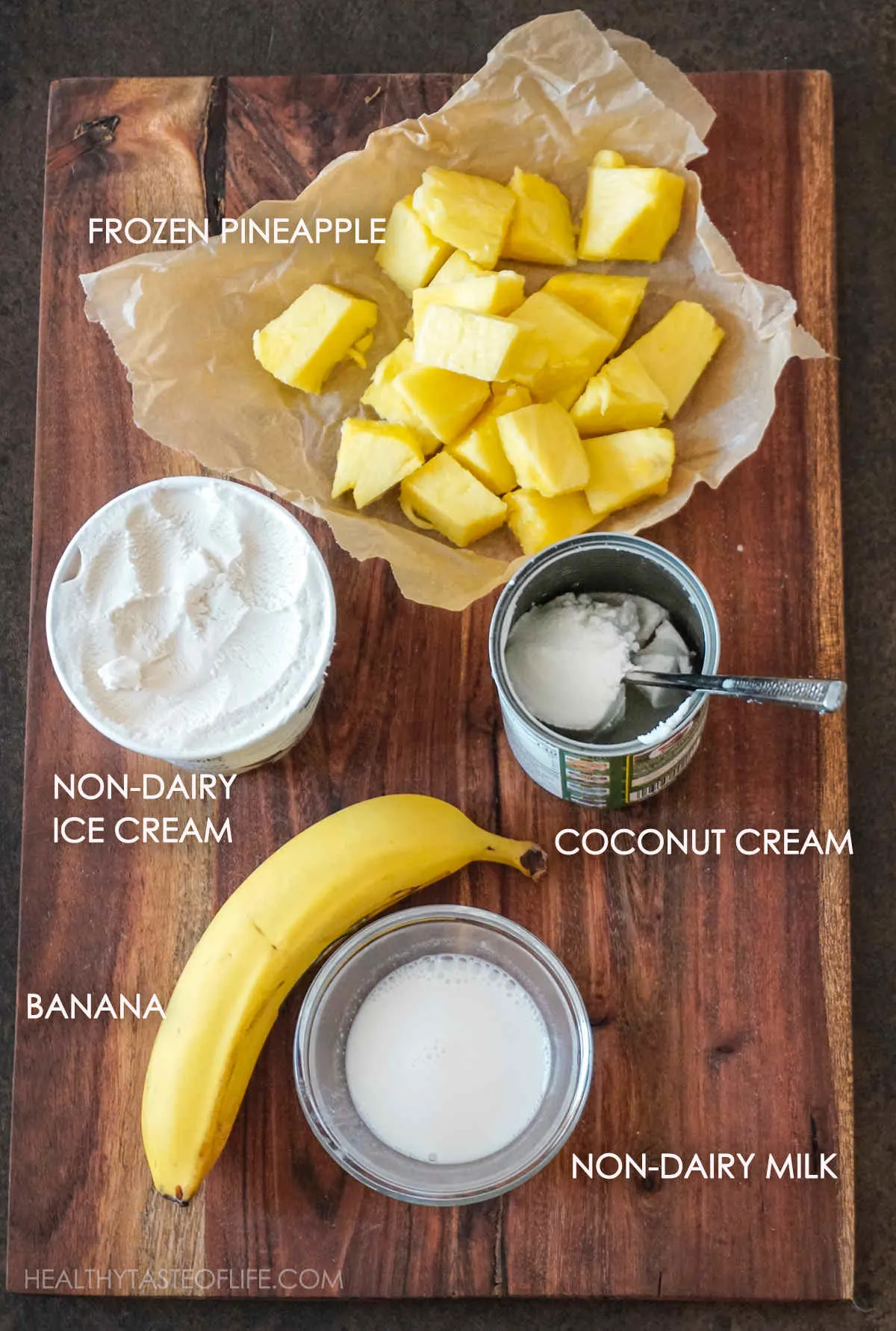 Ingredients for vegan pineapple milkshake displayed on a board, all measured up.