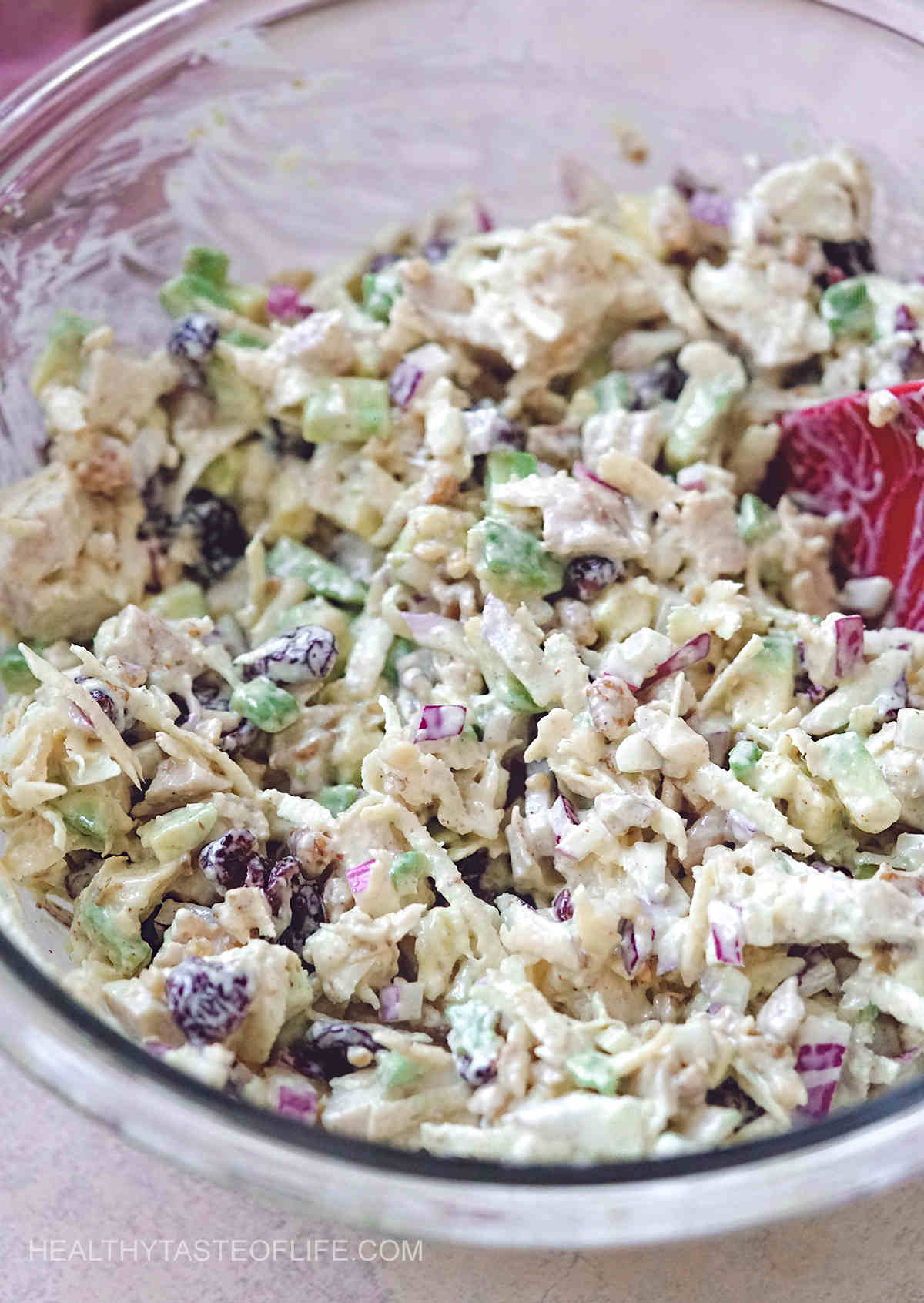 Mixed cranberry chicken walnut salad in a bowl.