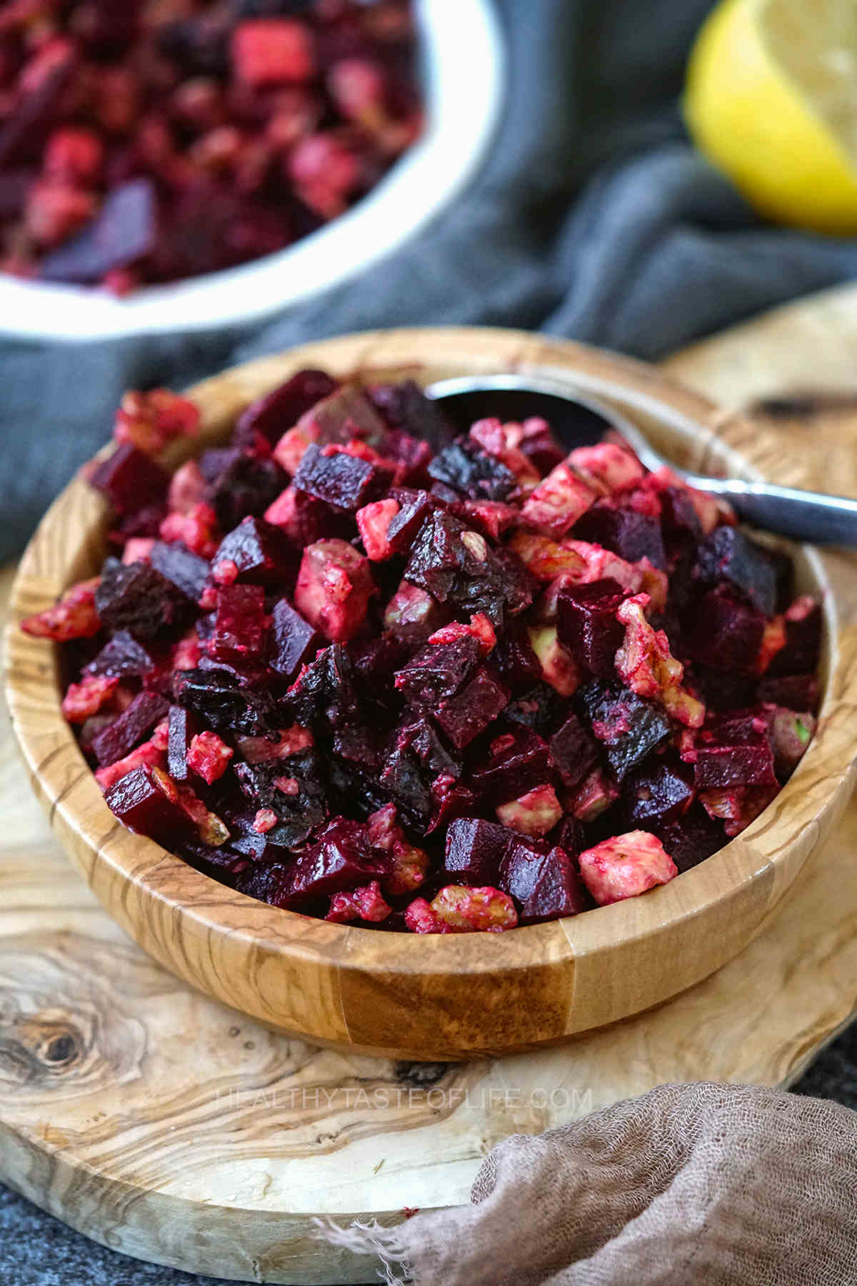 Russian salad with beets walnuts prunes and avocado - cold beet salad with vegan ingredients in a bowl.