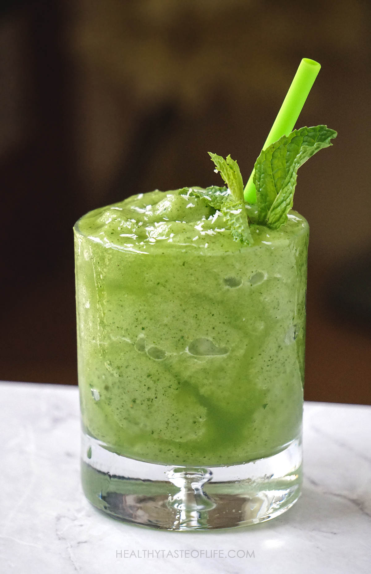 Honeydew smoothie with a thick consistency like slushy garnished with mint.