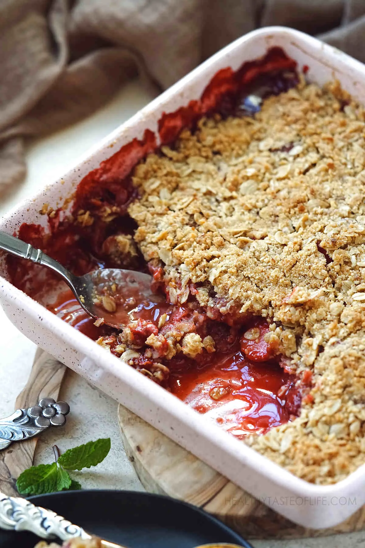  Picture showing the Juicy caramelized strawberry layer peaking beneath the crisp topping.