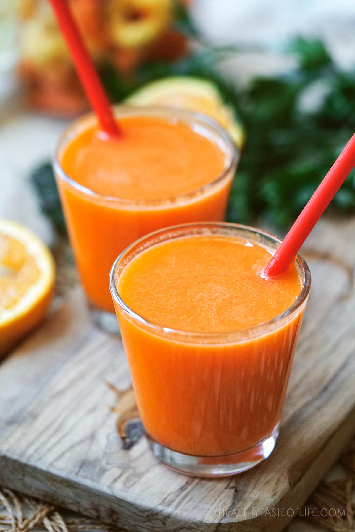 Immune booster juice made with carrot orange ginger - freshly made with a juicer and served in two short glasses.