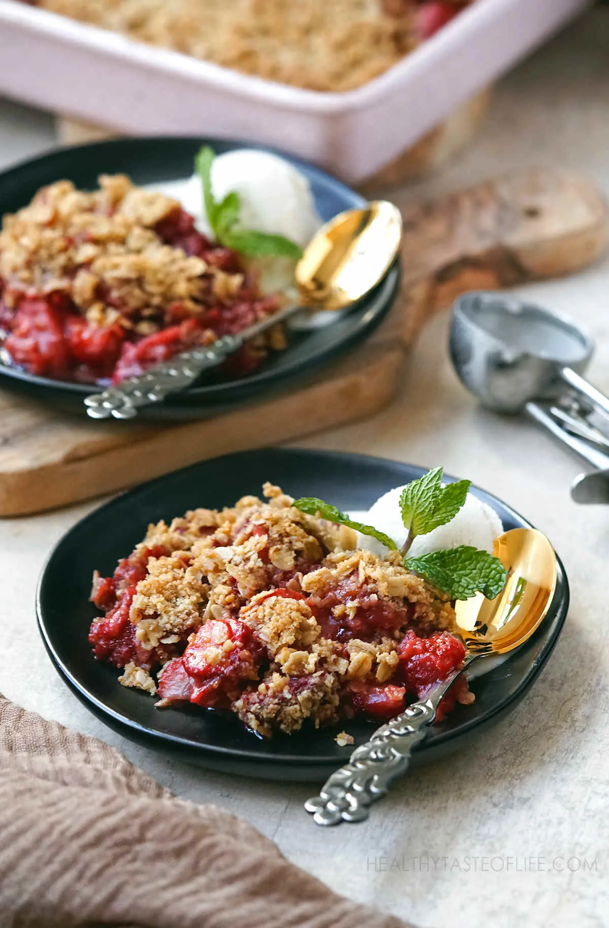 Healthier Strawberry Crumble Made With Fresh Strawberries and a crunchy oat topping served in two plates as dessert.