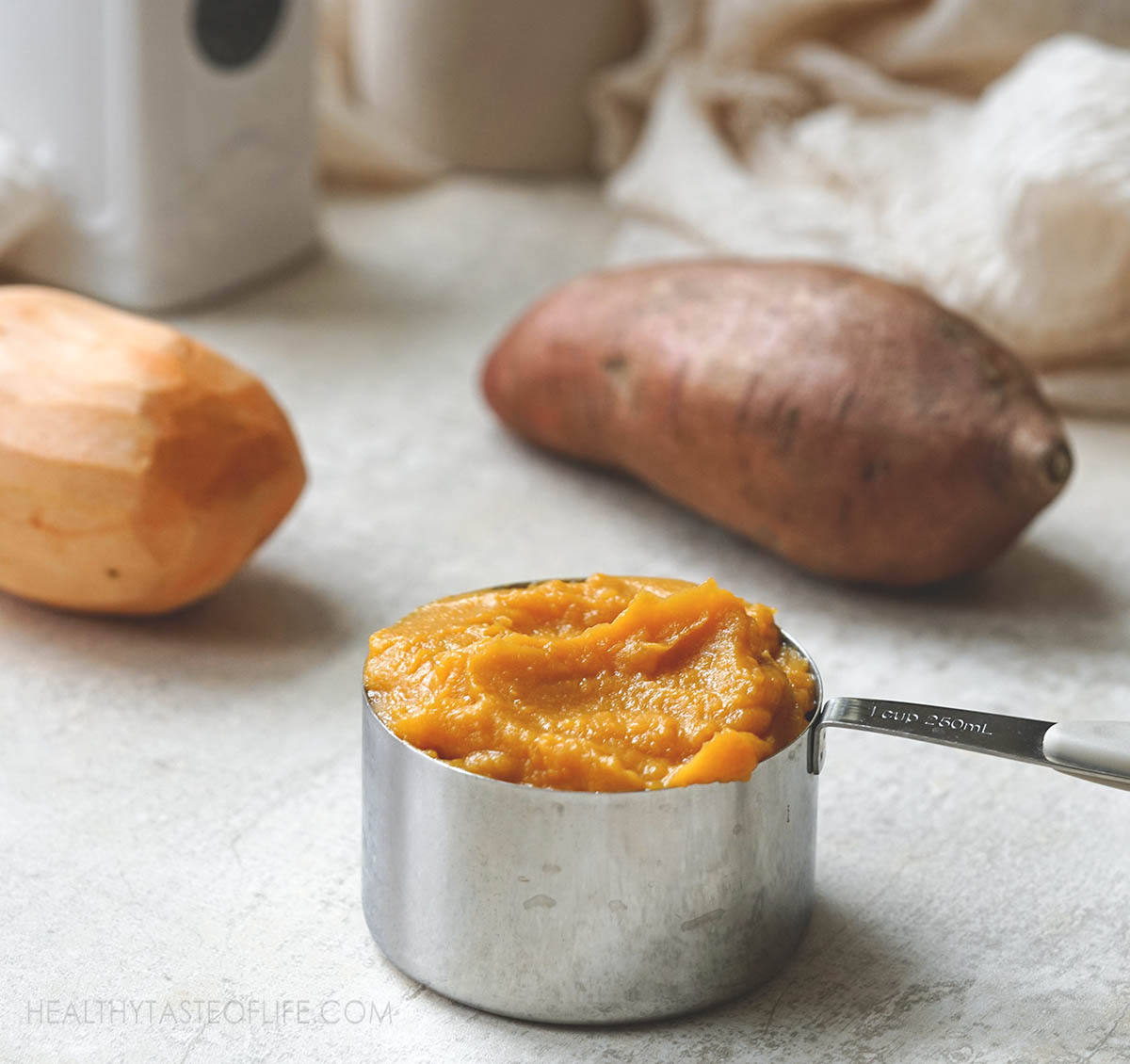 A cup with sweet potato puree or mashed.