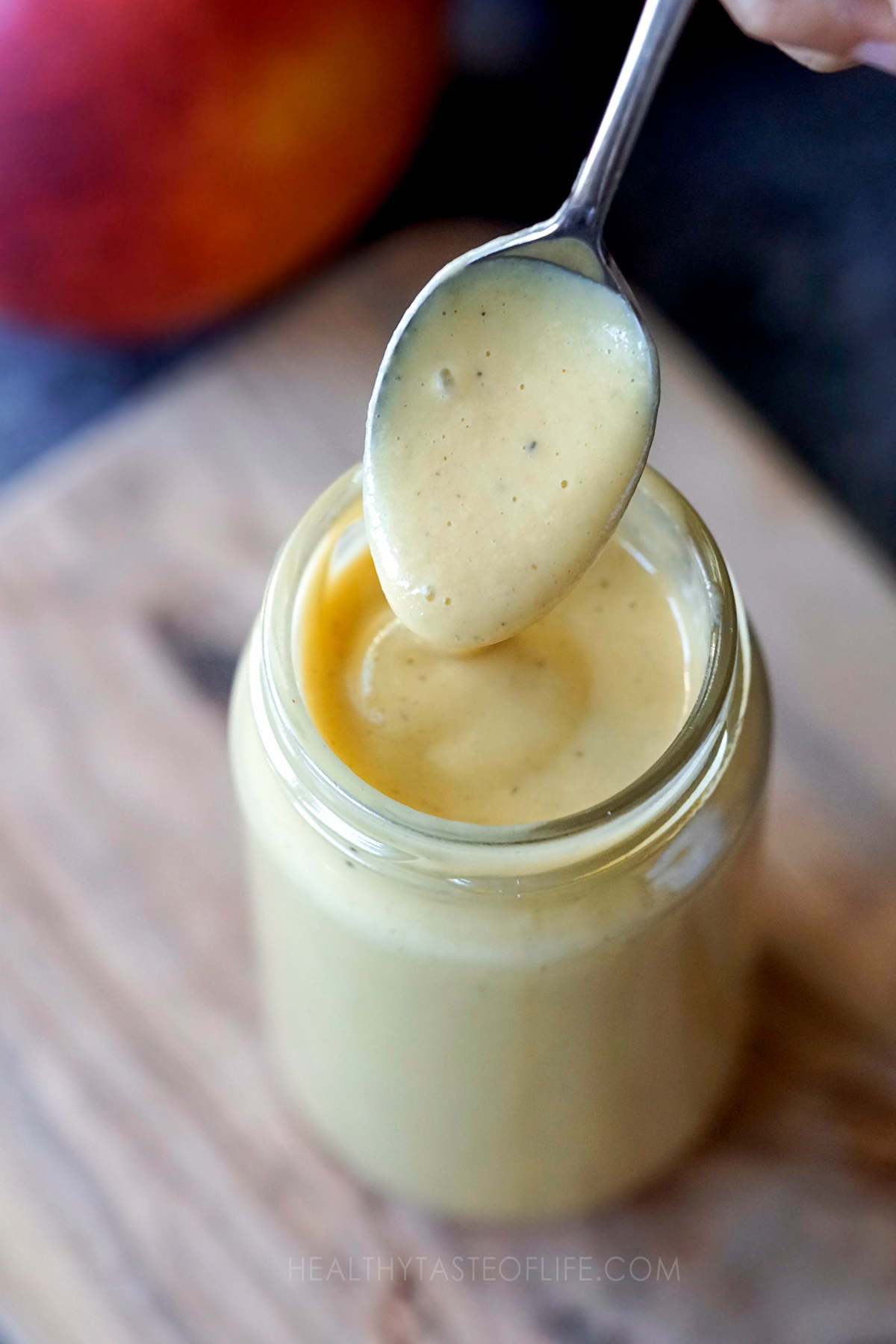 Creamy peach vinaigrette cooped with a spoon.