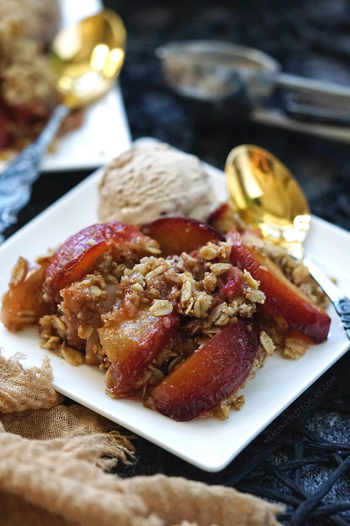 Apple plum crumble served with a scoop of ice cream.