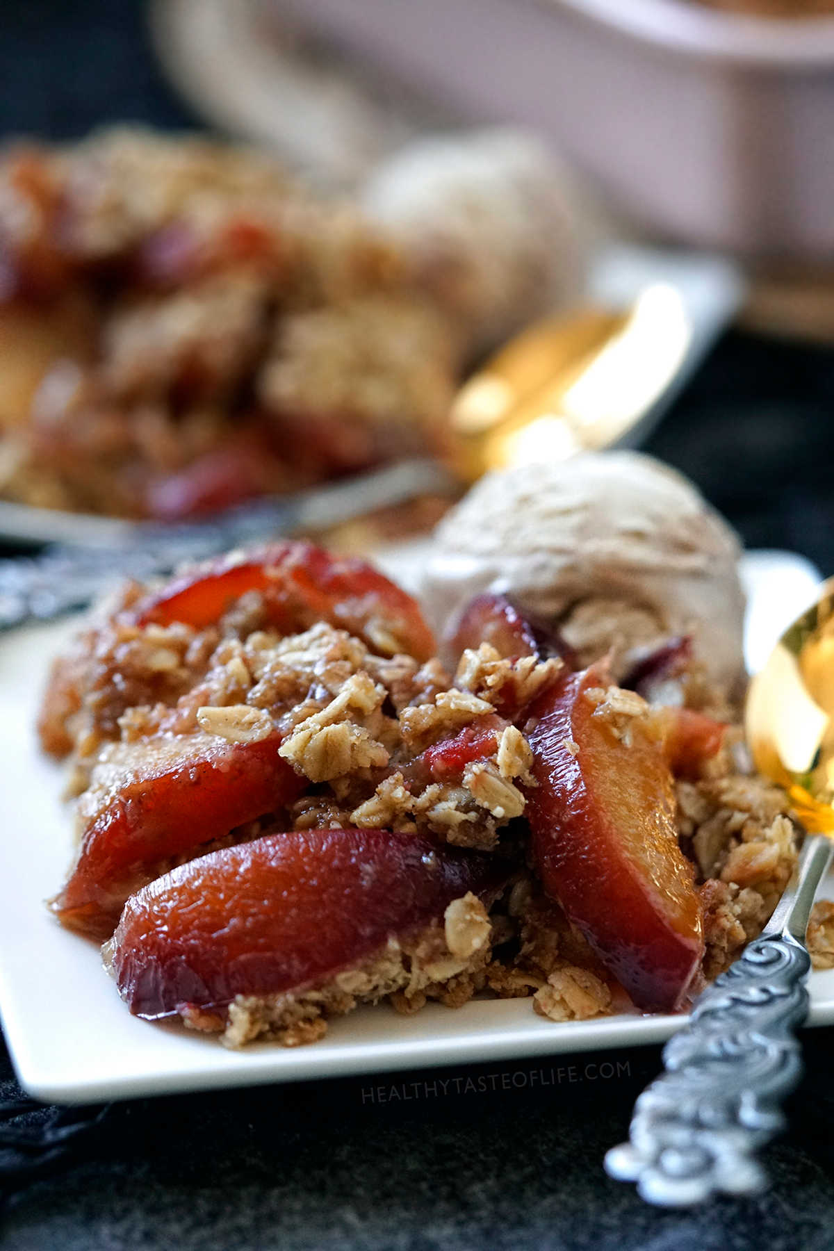 Apple And Plum Crumble with fresh apples and plums covered  with a crunchy oat crumble topping and baked in the oven.