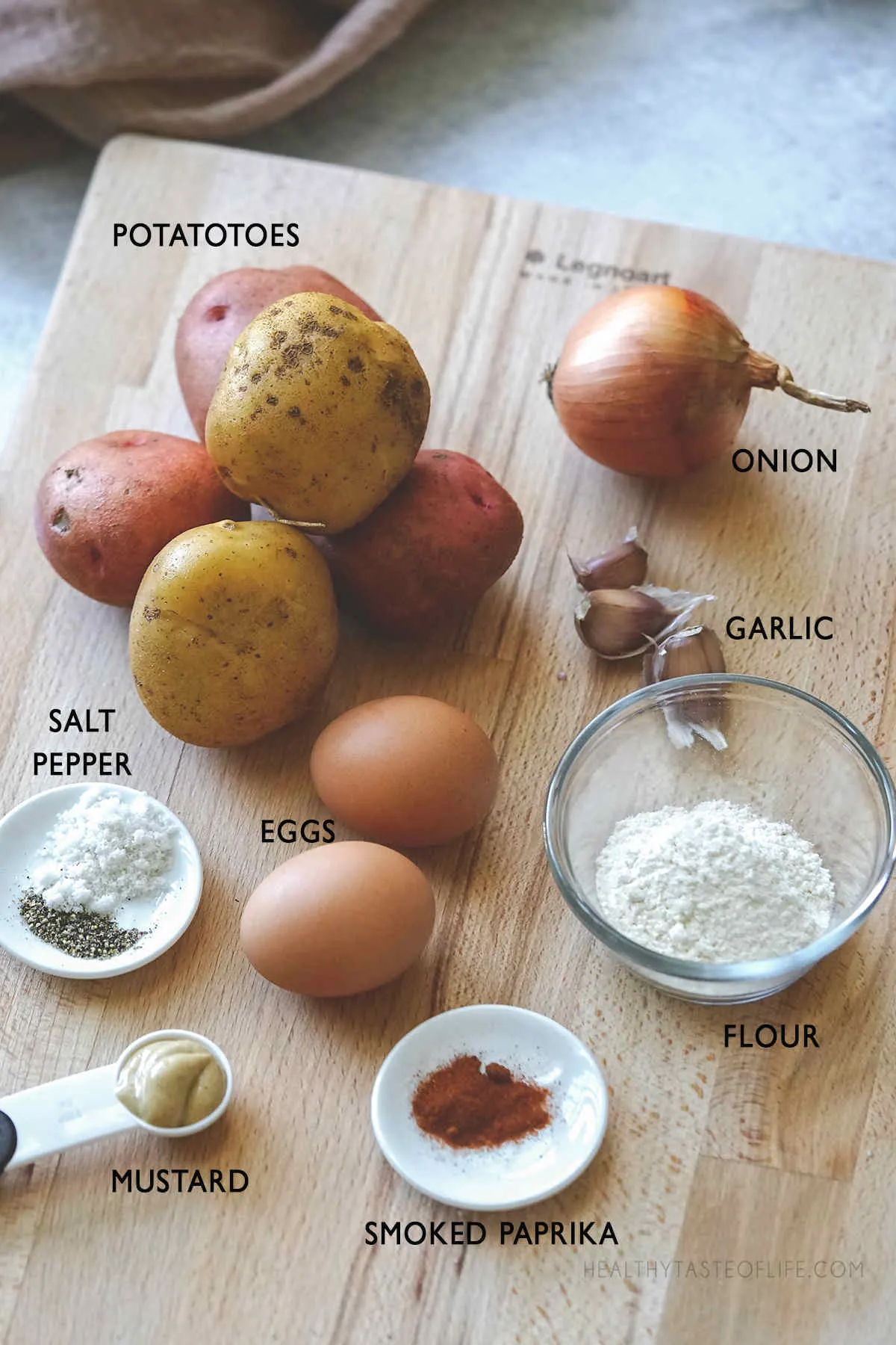 Ingredients for potato fritters displayed on a board.