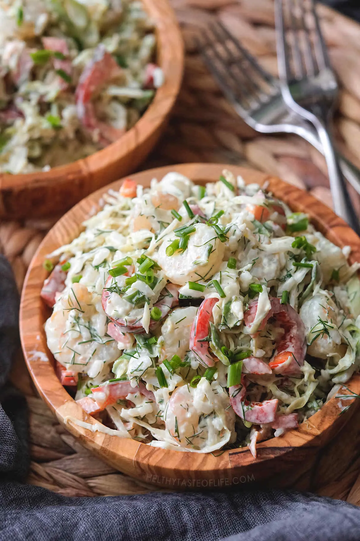 Shrimp and cabbage salad served in a wooden bowl.
