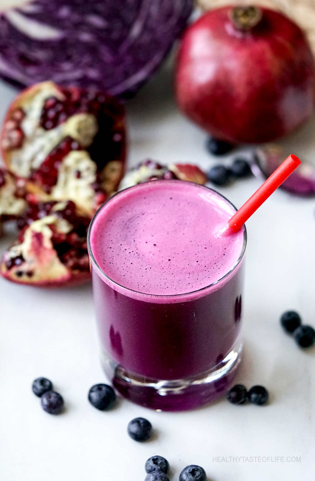 Cancer killer juice made with pomegranate, red cabbage and blueberries served in a glass.