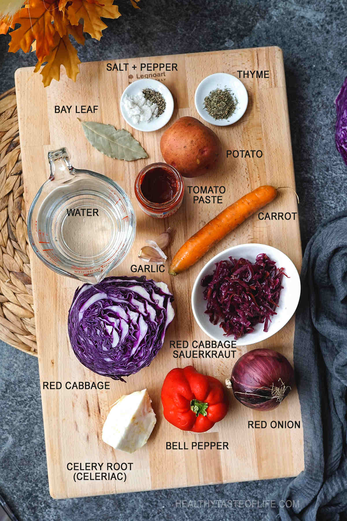 Image showing all ingredients for making a red cabbage soup displayed on a board (red cabbage, carrot, potato, onion, garlic, celery root, bell pepper, tomato paste, red cabbage sauerkraut and seasonings)