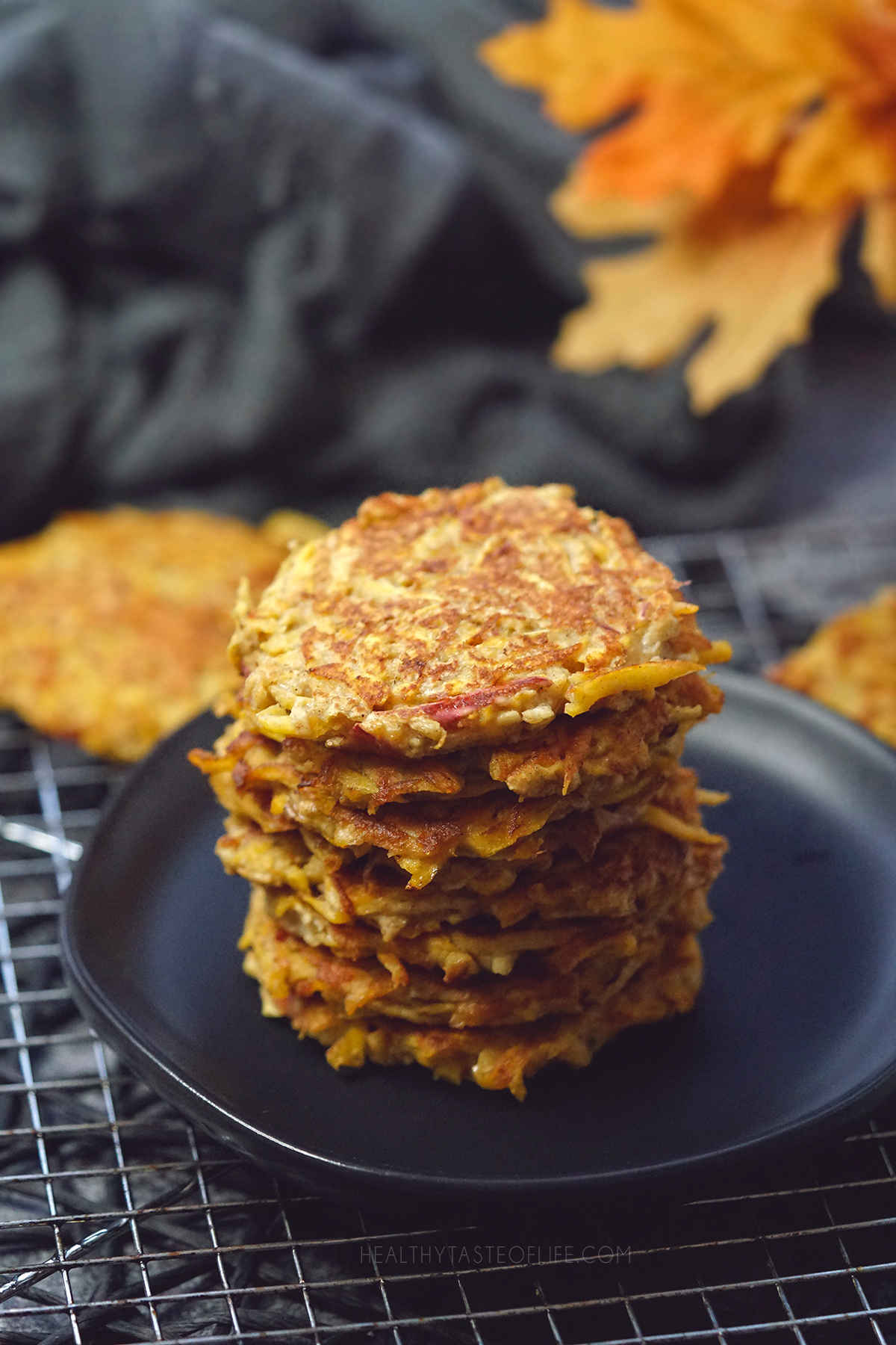 Pumpkin fritters stacked on a serving plate.