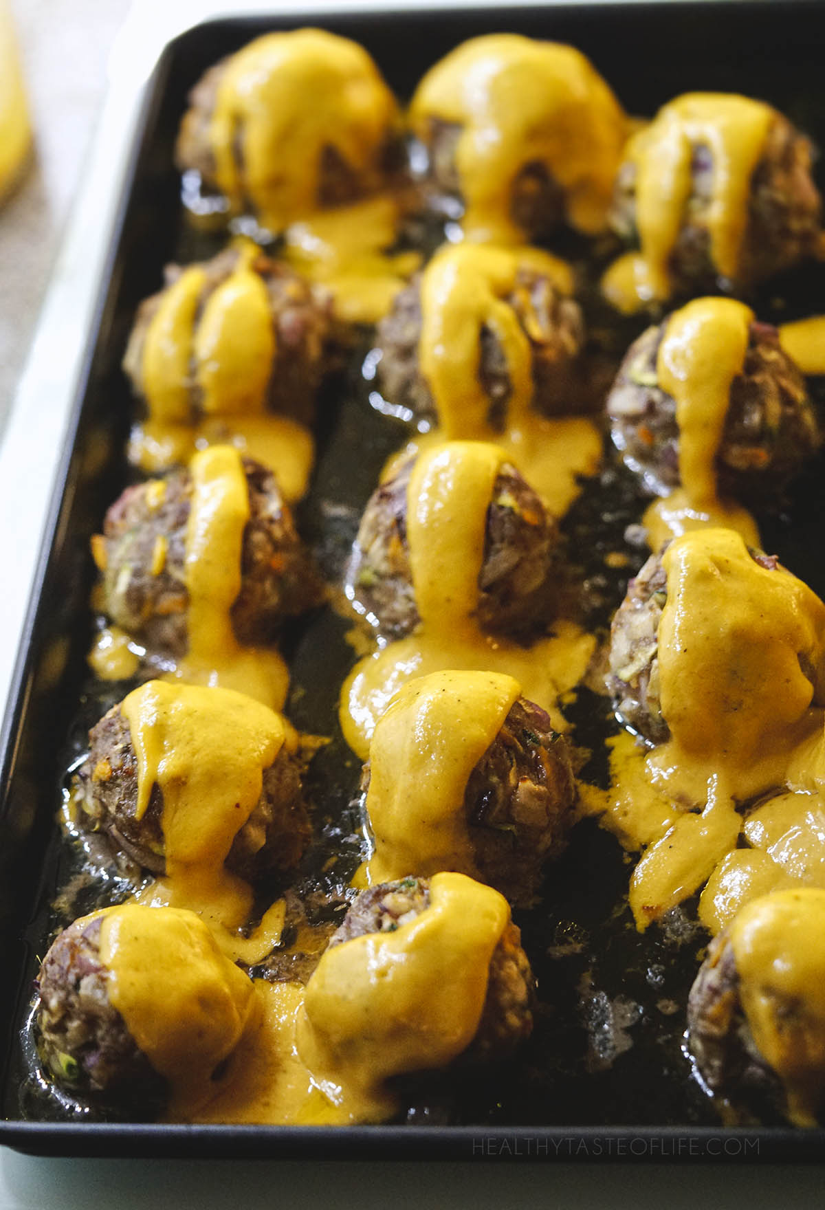 Light healthy beef meatballs covered in a creamy mango sauce without dairy.