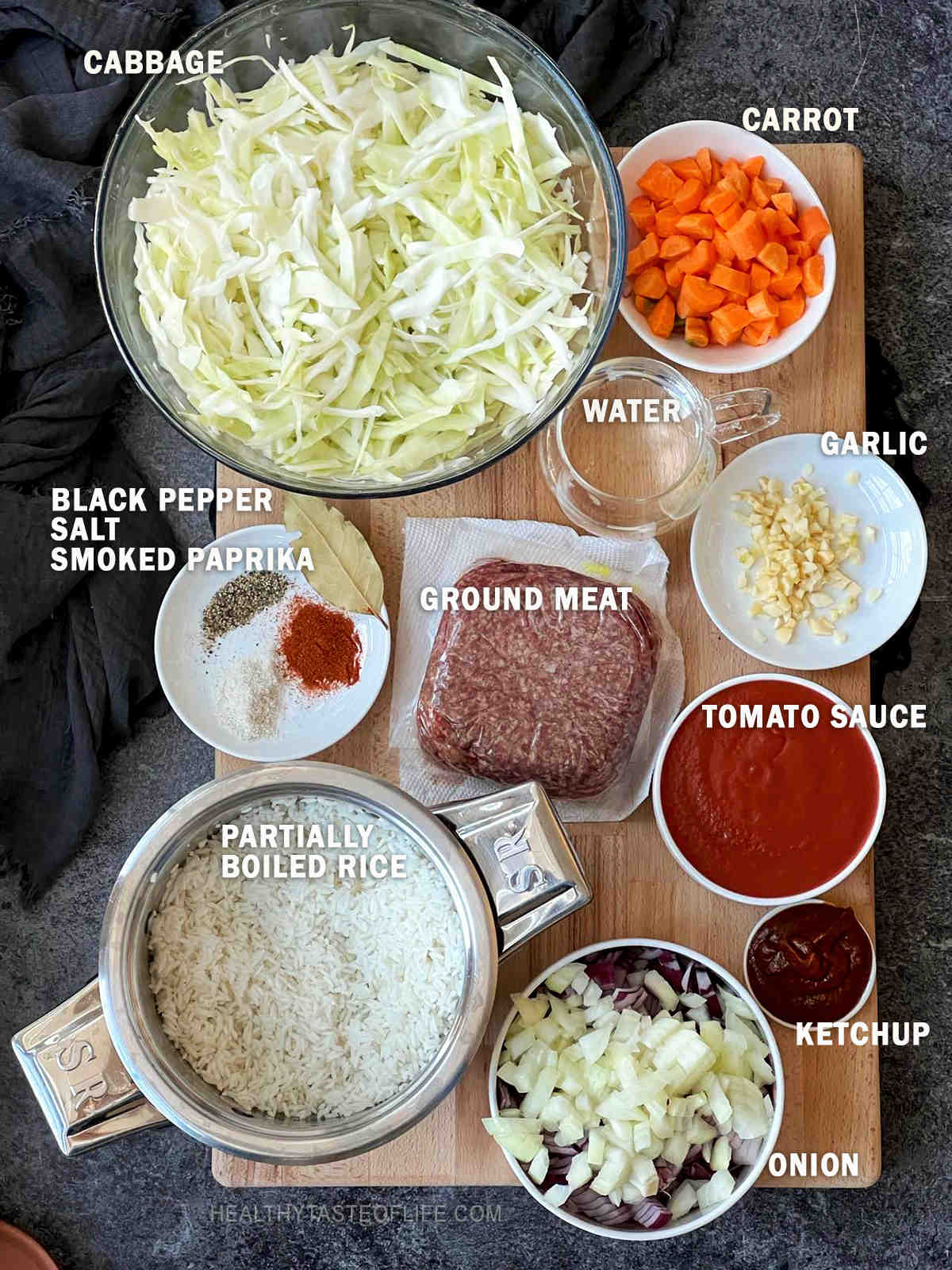 Image showing the ingredients for cabbage roll casserole recipe displayed on a board with exact measurements.