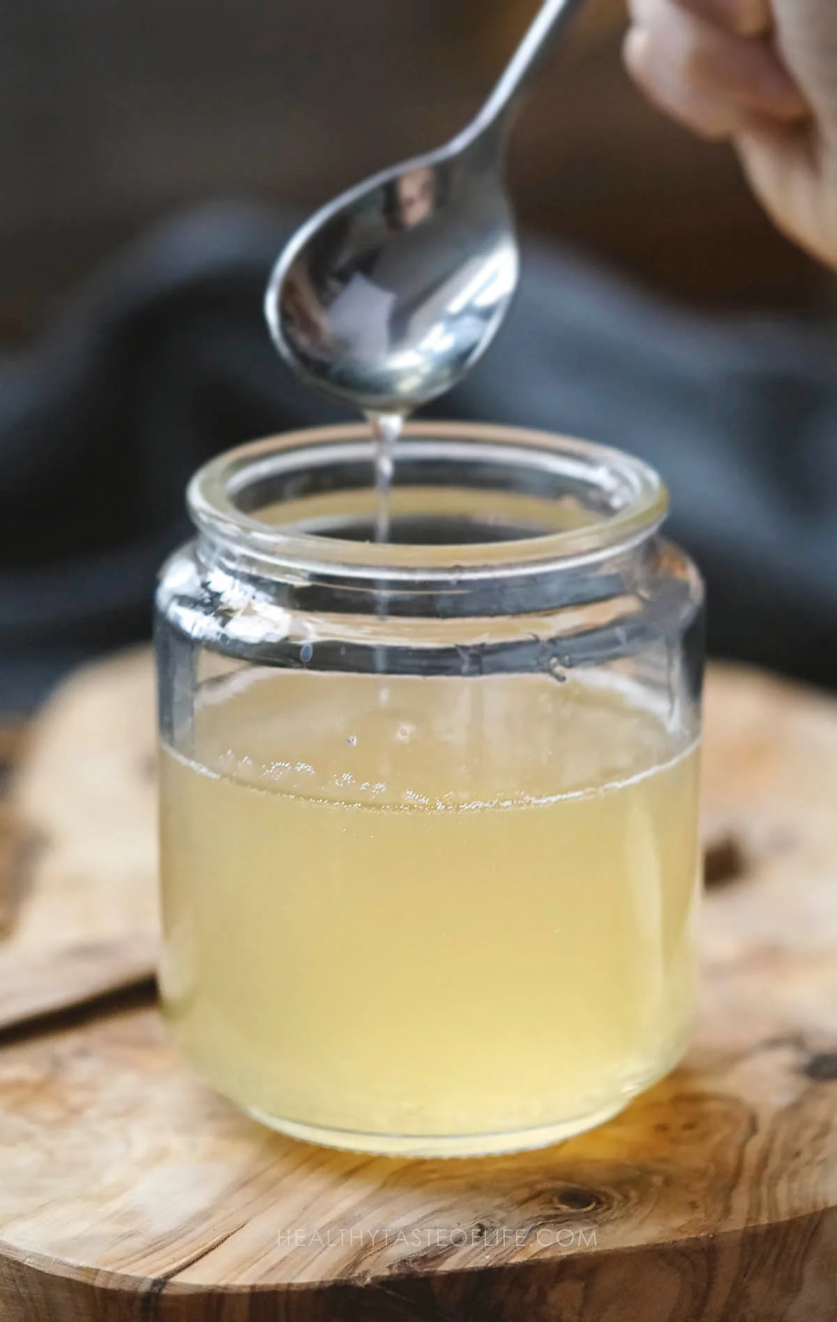 Natural homemade syrup for cough and sore throat in a jar mixed with a spoon.