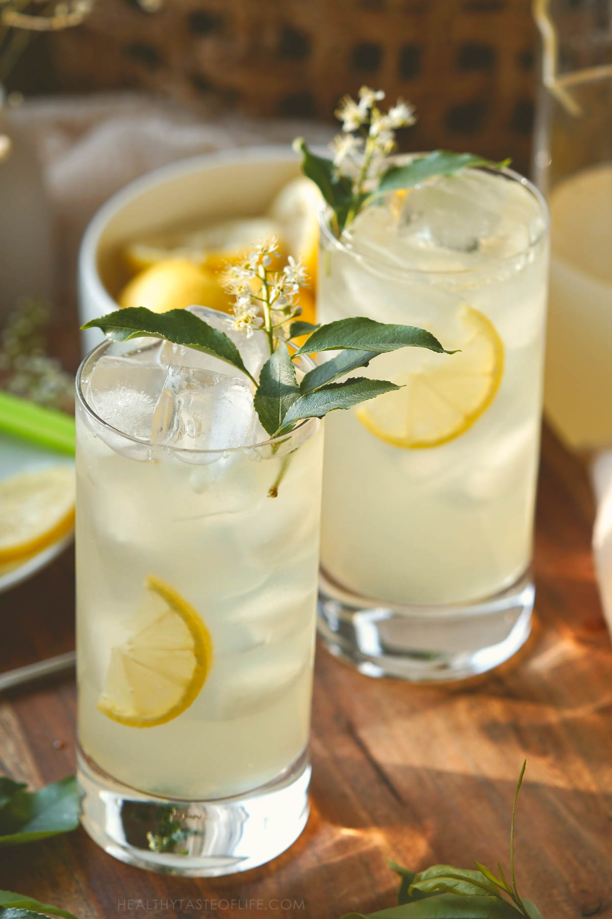 Photo of two high glasses filled with homemade elderflower lemonade served over ice.