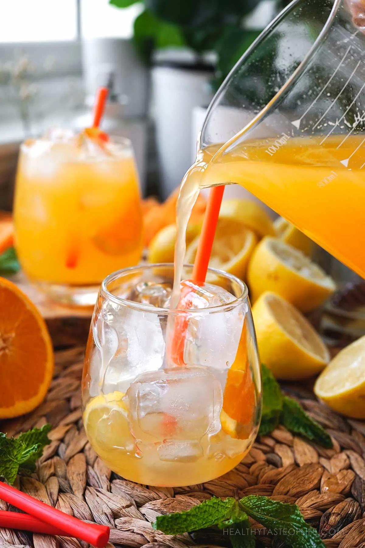 Picture showing pouring the orange lemonade in the glass.