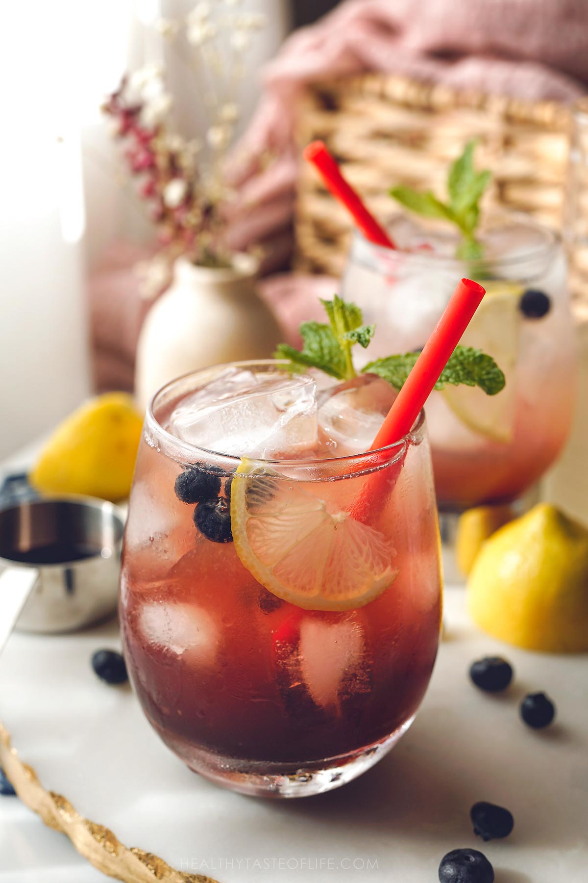 A glass of lemonade with elderberries.