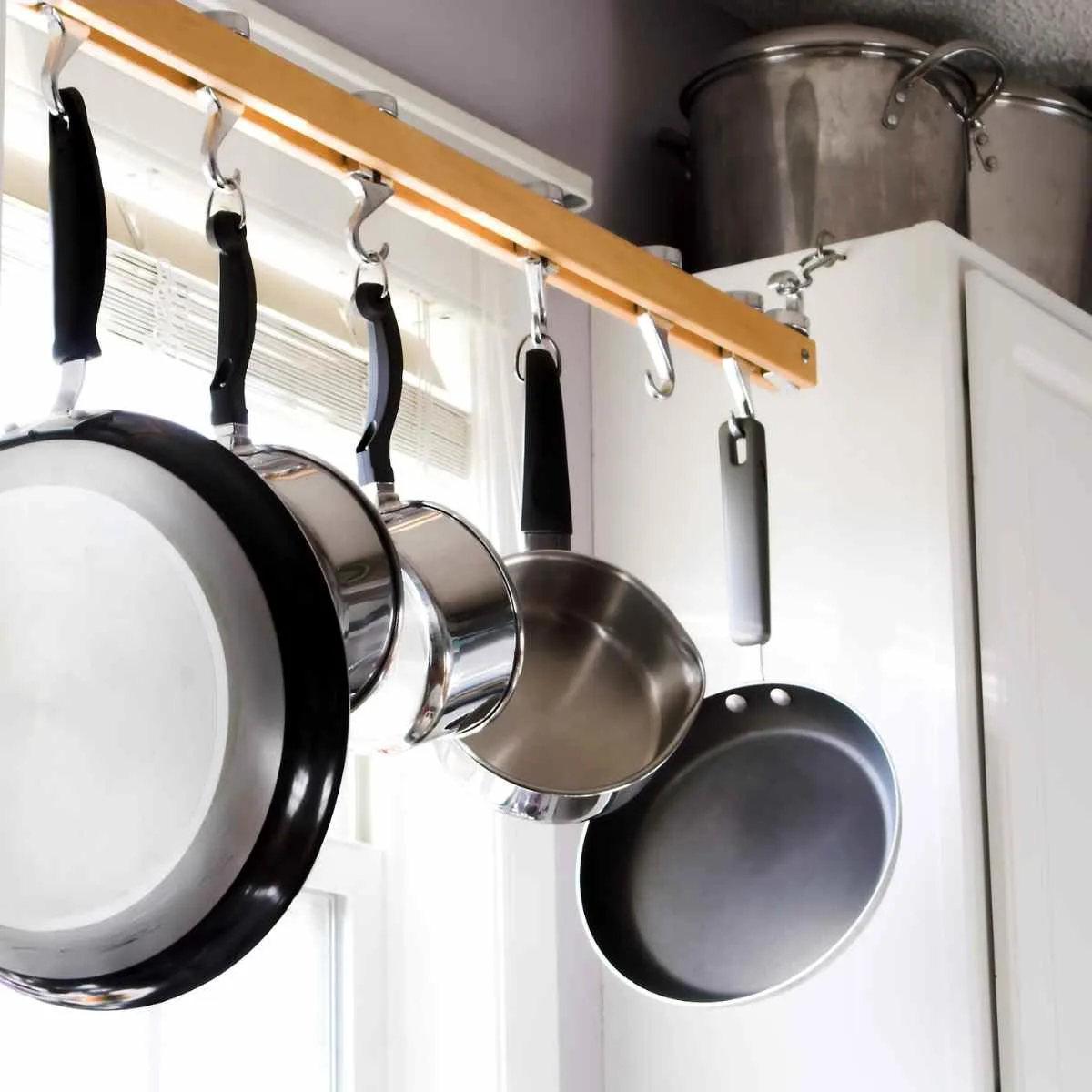 Diffrent types of non-toxic cookware hanging in the kitchen.
