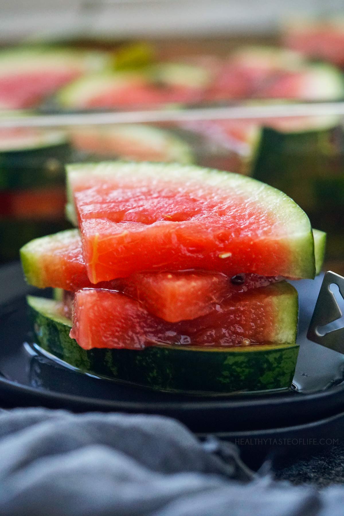 Ready fermented watermelon slices stacked on a plate.