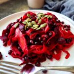 Festive beet pomegranate salad with orange tahini dressing, carrot ribbons and pumpkin seeds