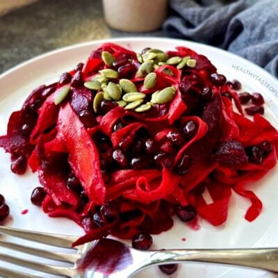 Festive beet pomegranate salad with orange tahini dressing, carrot ribbons and pumpkin seeds