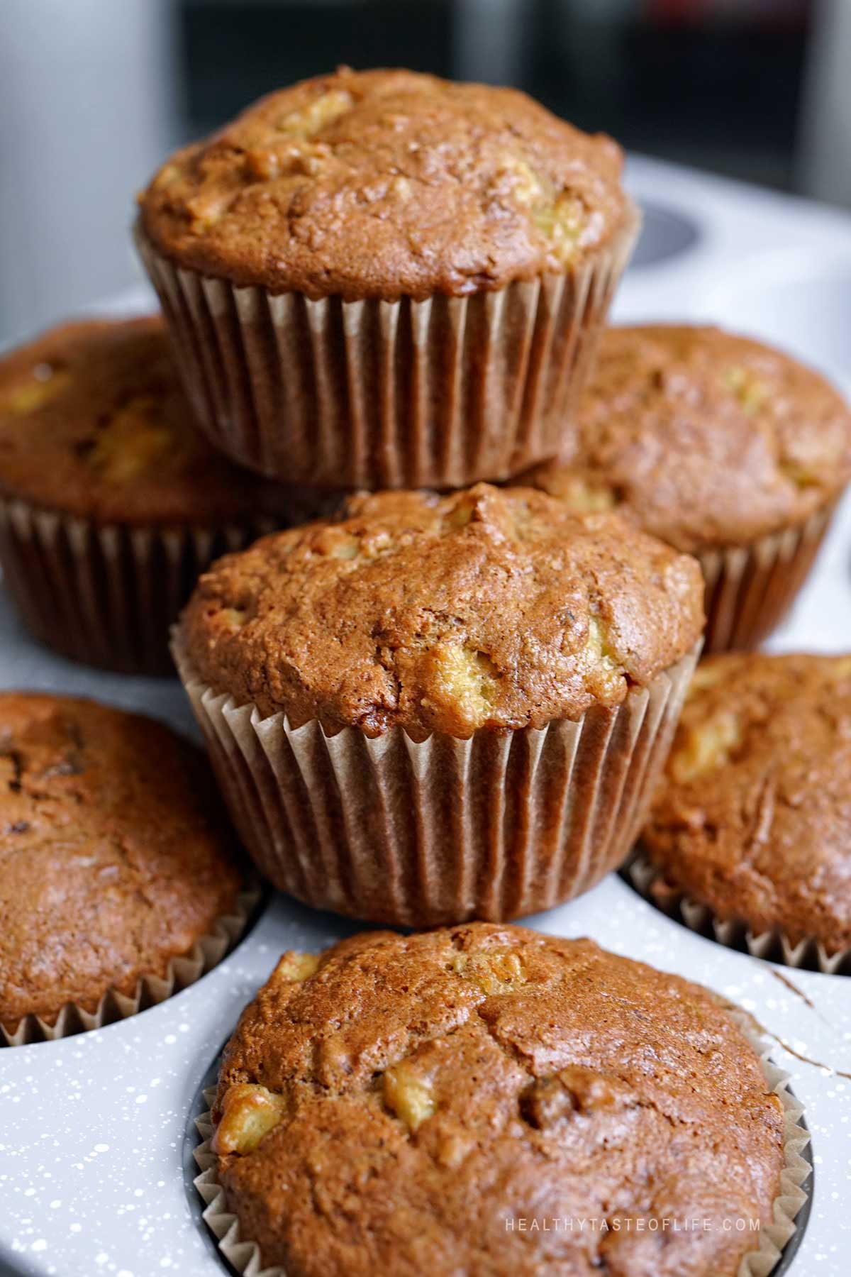 Staked baked gluten-free carrot pineapple muffins with walnuts and raisins cooling.
