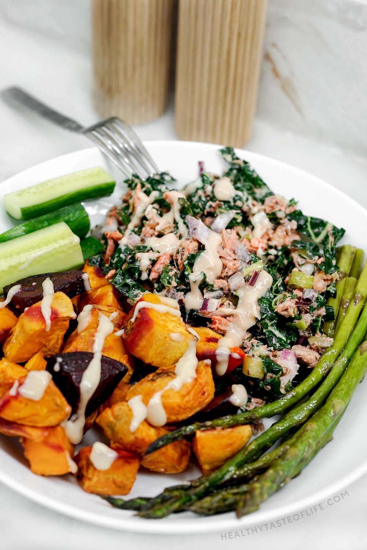 A dinner plate with high protein salad with salmon and sardines plus leftover cooked sweet potatoes and asparagus