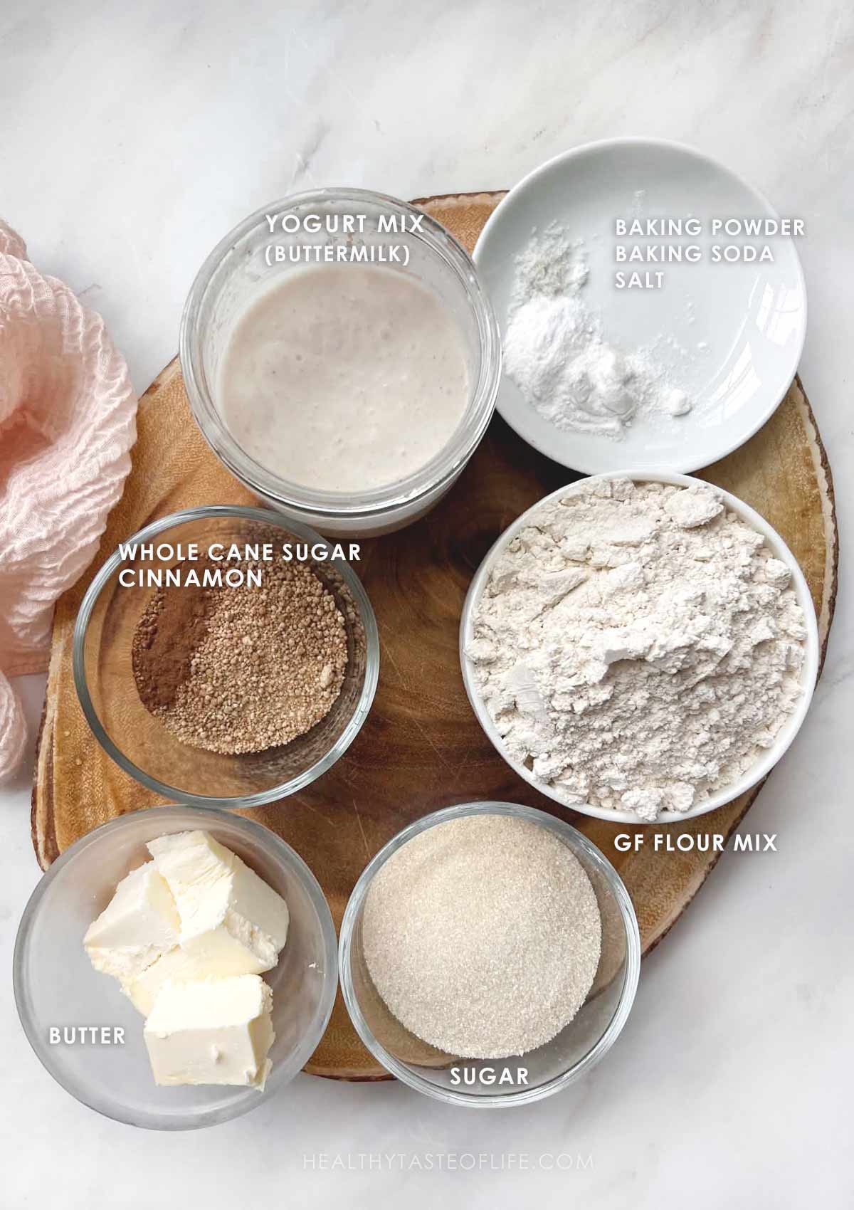 Measured biscuit ingredients displayed on a board- gf flour, sugar, butter, yogurt and baking powder