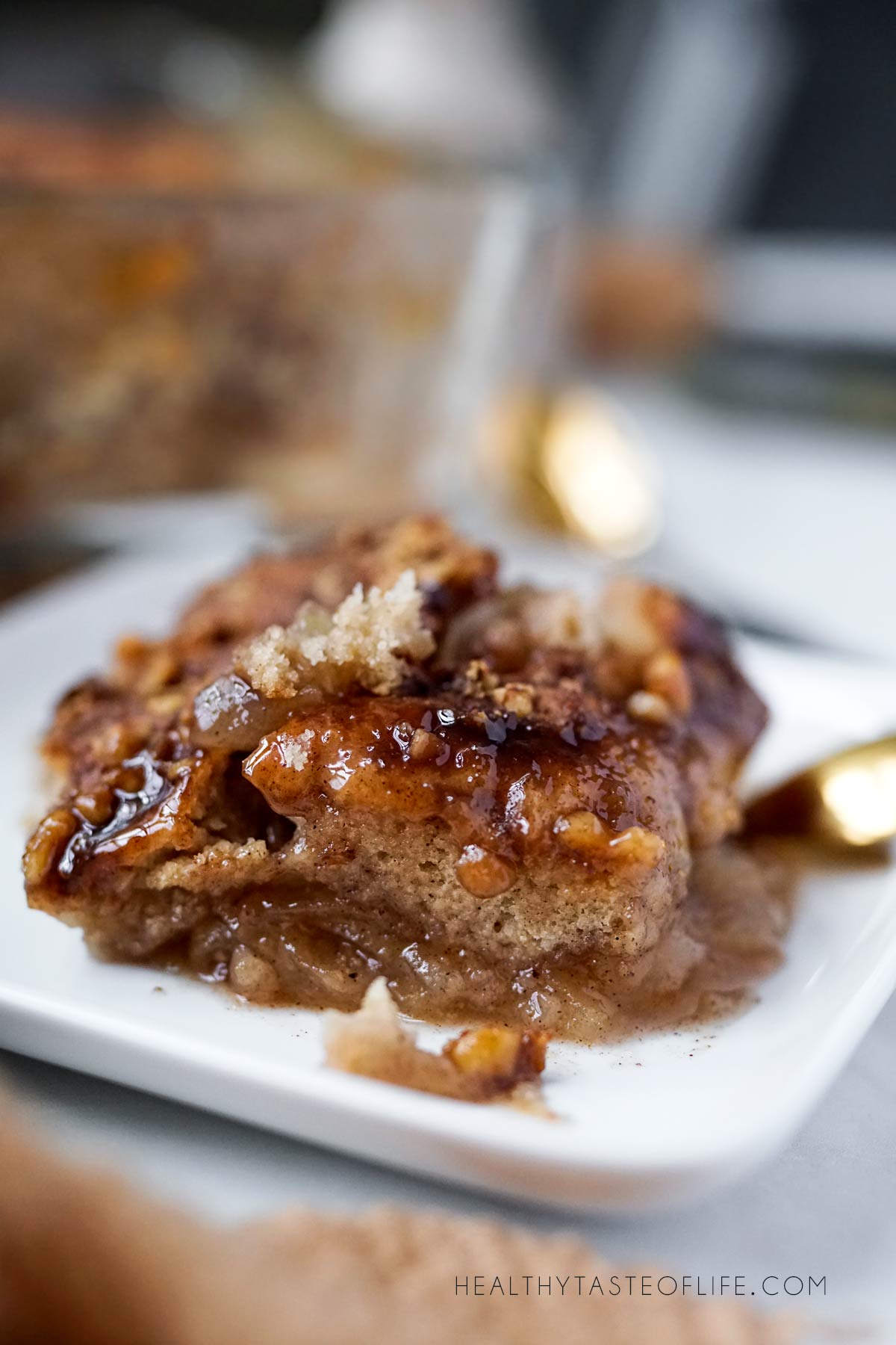 Small plate with warm apple cobbler showing soft caramelized apples and biscuit topping
